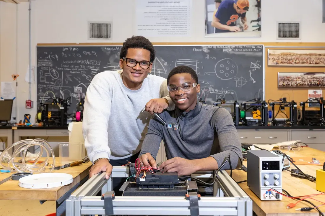 Two students sitting in a workplace.